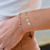 Woman wearing a Hope Newport 14k gold bracelet featuring alternating 4 mm amethysts, Nantucket blue topaz & sapphires