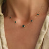 Woman with a Grand & Classic necklace featuring one 6 mm and four 4 mm Emeralds bezel set in 14k yellow gold