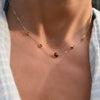 Woman wearing a Grand & Classic necklace featuring one 6 mm and four 4 mm Garnets bezel set in 14k yellow gold