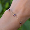 Woman with a Grand & Classic bracelet featuring one 6 mm and four 4 mm briolette Garnets bezel set in 14k yellow gold