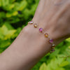 Woman wearing a Sunset Newport Grand 14k gold bracelet featuring alternating 6 mm briolette cut pink sapphires and citrines
