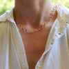 Woman with a Sunset Newport Grand necklace featuring alternating 6 mm pink sapphires and citrines bezel set in 14k gold