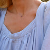 Woman wearing a Grand 14k yellow gold 1.17 mm cable chain necklace featuring one 6 mm briolette cut bezel set amethyst