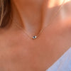 Woman with a Grand 14k gold 1.17 mm cable chain necklace featuring one 6 mm briolette cut bezel set Nantucket blue topaz