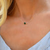 Woman wearing a Grand 14k yellow gold 1.17 mm cable chain necklace featuring one 6 mm briolette cut bezel set emerald