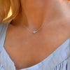 Woman with a Grand 14k yellow gold 1.17 mm cable chain necklace featuring one 6 mm briolette cut bezel set moonstone
