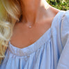 Woman wearing a Grand 14k yellow gold 1.17 mm cable chain necklace featuring one 6 mm briolette cut bezel set pink opal
