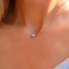 Woman with a Grand 14k yellow gold 1.17 mm cable chain necklace featuring one 6 mm briolette cut bezel set turquoise