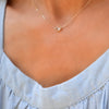 Woman with a Grand 14k yellow gold 1.17 mm cable chain necklace featuring one 6 mm briolette cut bezel set white topaz