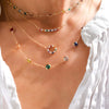 Woman with multiple necklaces including a Grand 14k gold necklace featuring seven 6 mm rainbow hued briolette cut gemstones
