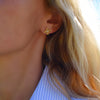 Woman wearing a 14k yellow gold Greenwich 4 Birthstone earring featuring four 4 mm citrines and one 2.1 mm diamond
