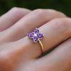 Woman wearing a Greenwich ring featuring four 4 mm faceted round cut amethysts and one 2.1 mm diamond prong set in 14k gold