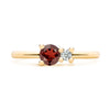 Greenwich ring featuring one 4 mm faceted round cut garnet and one 2.1 mm diamond prong set in 14k yellow gold - front view