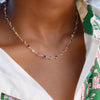 Woman wearing a Newport necklace featuring alternating 4 mm briolette cut rainbow hued gemstones bezel set in 14k gold