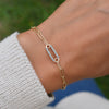 Woman wearing a 14k gold Adelaide paperclip chain pavé bracelet featuring one Nantucket blue topaz-encrusted link