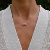 Woman with a 14k gold Adelaide paperclip chain necklace featuring one link encrusted with 1.5 mm pavé pink sapphires