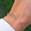 Woman wearing a 14k yellow gold Adelaide paperclip chain pavé bracelet featuring Nantucket blue topaz-encrusted links