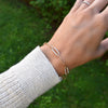 Woman wearing a 14k gold Adelaide paperclip chain pavé bracelet featuring diamond-encrusted links