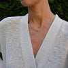 Woman wearing a 14k gold Adelaide paperclip chain necklace featuring five links encrusted with 1.5 mm pavé alexandrites