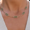 Woman with a 14k gold Adelaide paperclip chain necklace featuring five links encrusted with 1.5 mm pavé emeralds