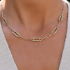 Woman with a 14k yellow gold Adelaide paperclip chain necklace featuring five links encrusted with 1.5 mm pavé peridots