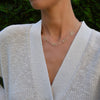 Woman wearing a 14k gold Adelaide paperclip chain necklace featuring five links encrusted with 1.5 mm pavé peridots