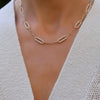 Woman with a 14k yellow gold Adelaide paperclip chain pavé necklace featuring six gemstone-encrusted links