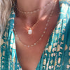 Woman wearing two necklaces including a Newport Wrap necklace featuring 4 mm briolette cut moonstones bezel set in 14k gold