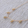 Close-up of a Providence 5 Peridot drop necklace with petite baguette cut stones set in 14k yellow gold