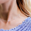 Woman wearing a Bayberry 11 Birthstone necklace featuring 4 mm briolette moonstones bezel set in sterling silver