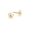 Pair of 14k yellow gold stud earrings each featuring one 1/4” flat disc engraved with the letter K - front view