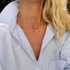 Woman wearing a 14k yellow gold cable chain necklace featuring one 1/4” flat disc engraved with the letter F