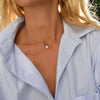 Woman wearing a 14k yellow gold cable chain necklace featuring one 1/4” flat disc engraved with the letter I