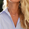 Woman wearing a 14k yellow gold cable chain necklace featuring one 1/4” flat disc engraved with the letter N