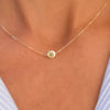 Woman with a 14k yellow gold cable chain necklace featuring one 1/4” flat disc engraved with the letter P