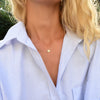 Woman wearing a 14k yellow gold cable chain necklace featuring one 1/4” flat disc engraved with the letter U