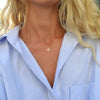Woman wearing a 14k yellow gold cable chain necklace featuring one 1/4” flat disc engraved with the letter Y