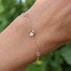 Woman with a Grand & Classic bracelet featuring one 6 mm and four 4 mm briolette Moonstones bezel set in 14k yellow gold