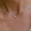 Woman wearing a Grand & Classic necklace featuring one 6 mm and four 4 mm Moonstones bezel set in 14k yellow gold