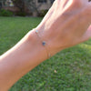 Woman wearing a Grand & Classic bracelet featuring one 6 mm & four 4 mm briolette Nantucket Blue Topaz bezel set in 14k gold