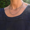 Woman with a Newport Wrap necklace featuring 4 mm briolette cut sapphires bezel set in 14k yellow gold