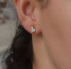 Woman wearing a 14k yellow gold Greenwich 1 Birthstone earring featuring one 4 mm moonstone and one 2.1 mm diamond
