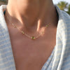 Woman wearing a Grand & Classic necklace featuring one 6 mm and four 4 mm Peridots bezel set in 14k yellow gold