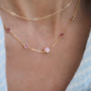 Woman with a Grand & Classic necklace featuring one 6 mm Pink Opal and four 4 mm Pink Tourmalines bezel set in 14k gold
