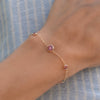 Woman wearing a Grand & Classic bracelet featuring one 6 mm Pink Sapphire & four 4 mm Pink Tourmalines bezel set in 14k gold