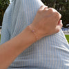 Woman with a Grand & Classic bracelet featuring one 6 mm Pink Sapphire and four 4 mm Pink Tourmalines bezel set in 14k gold