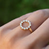 Hand wearing a Rosecliff small open circle ring featuring twelve 2 mm round cut aquamarines prong set in 14k yellow gold