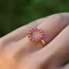 Woman's hand wearing a Rosecliff small open circle ring featuring twelve 2 mm round cut rubies prong set in 14k yellow gold