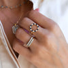 Woman wearing jewelry including a gold Rosecliff open circle ring featuring 16 alternating round cut sapphires and diamonds