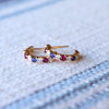Pair of Liberty Rosecliff huggie earrings in 14k yellow gold featuring nine alternating rubies, sapphires and diamonds